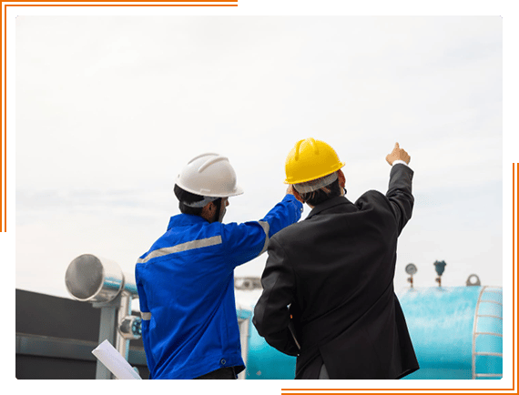 two men in hard hats and blue jackets standing next to each other