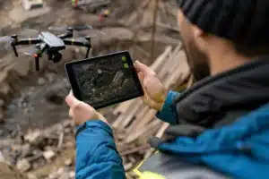 Worker watching a drone camera feed on a tablet at a construction site