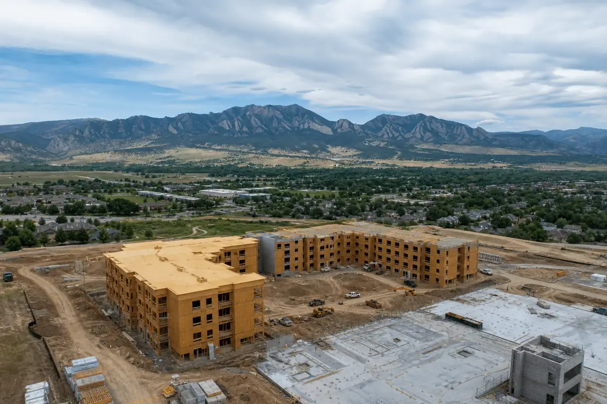 How Construction Drone Services Reduce Project Costs in Colorado 2 Apartment buildings under construction below the Colorado foothills